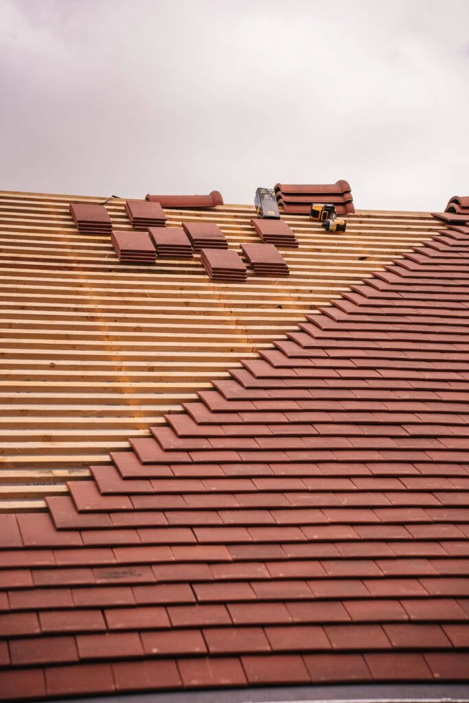 Professional roofing contractor installing a new asphalt shingle roof on a residential home in Driftwood Acres using modern tools and safety equipment.